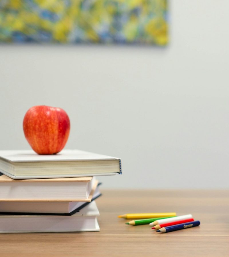 red apple fruit on four pyle books